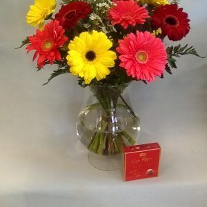 Ramo de gerberas de colores con bombones y jarron de cristal