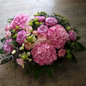 Cesta de flores tonos rosas.