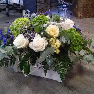 Centro de flores en caja de madera.